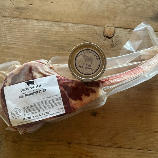 Packaged beef tomahawk steak with seasoning on a wooden surface