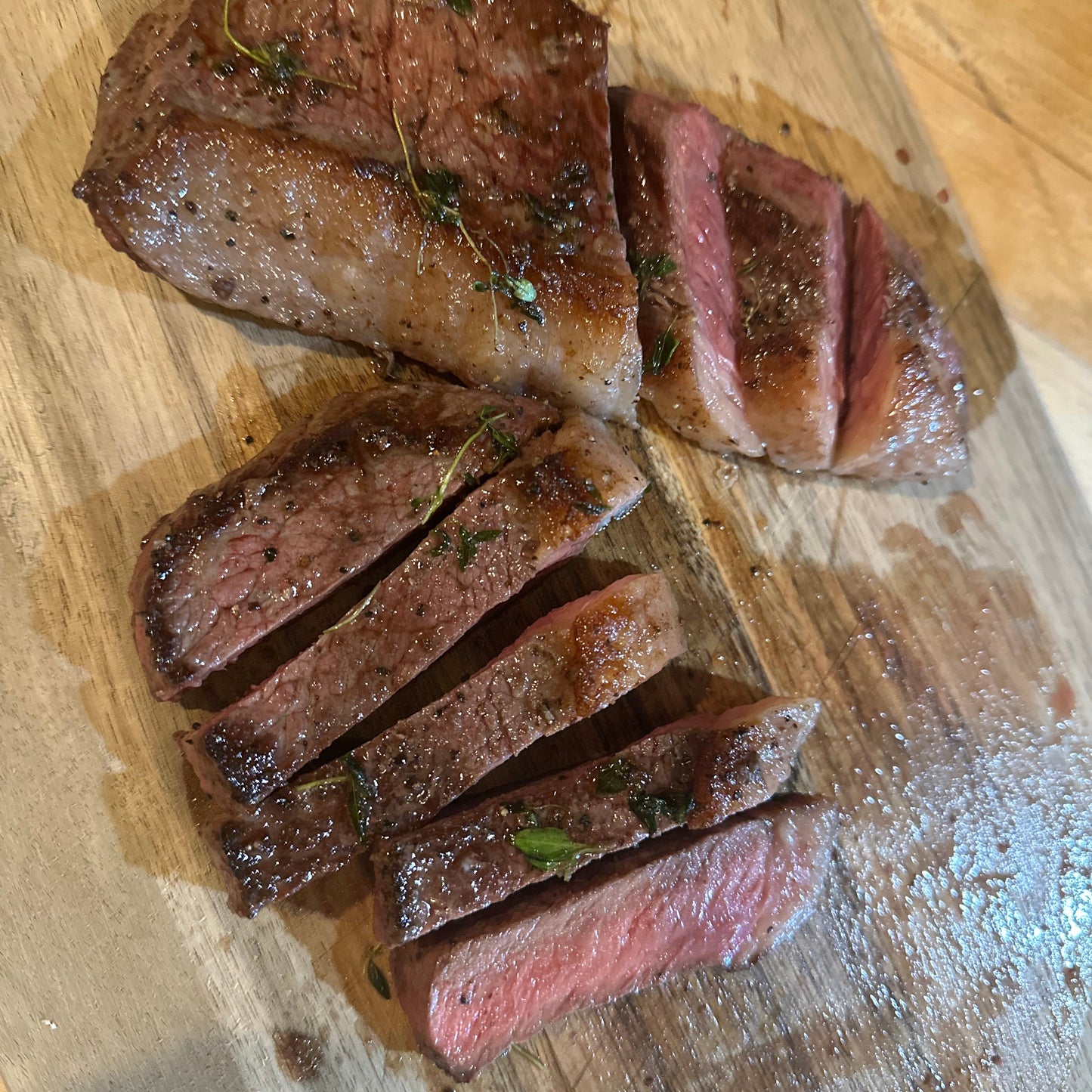 Sliced steak on a wooden cutting board
