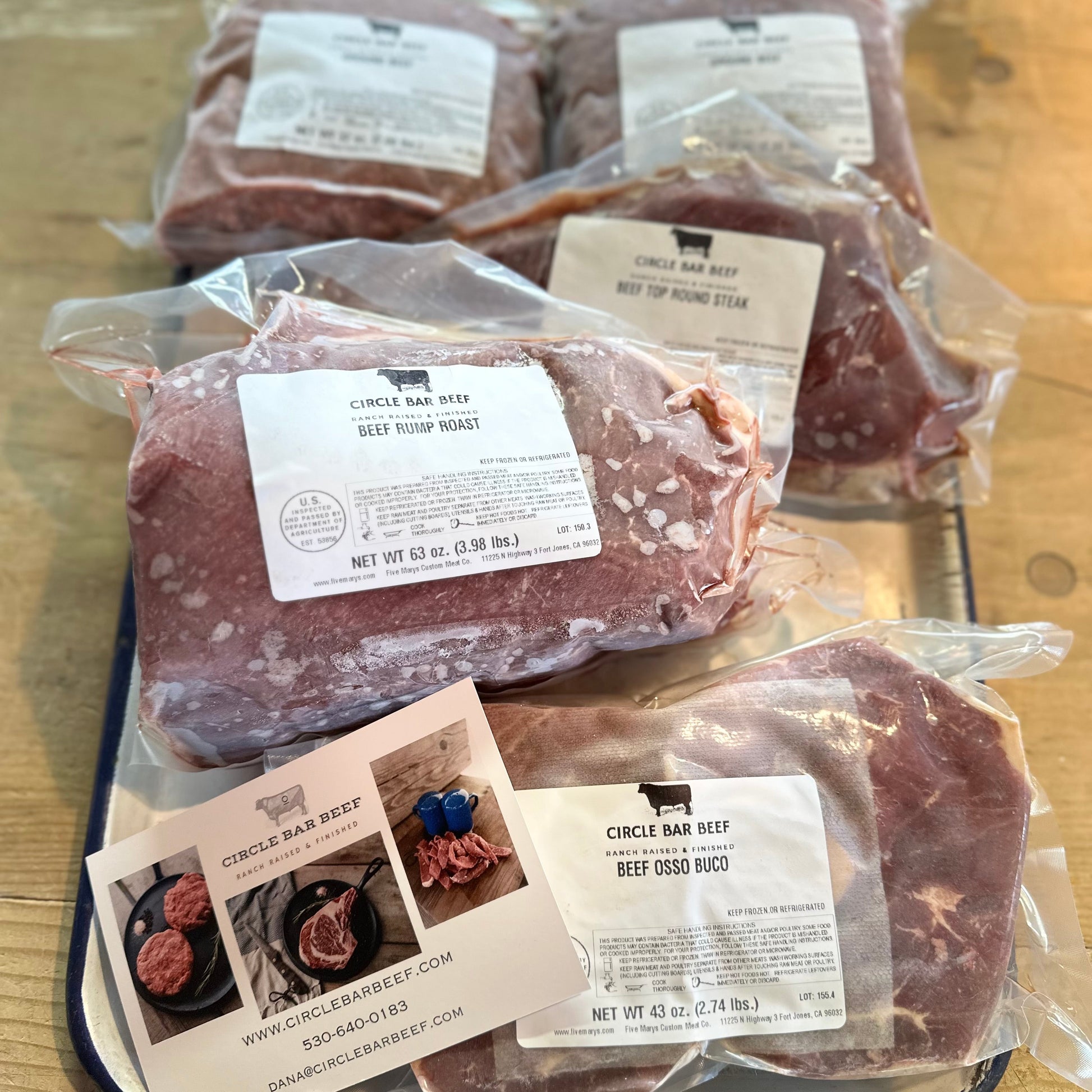 Packaged beef on a wooden surface with visible labels.