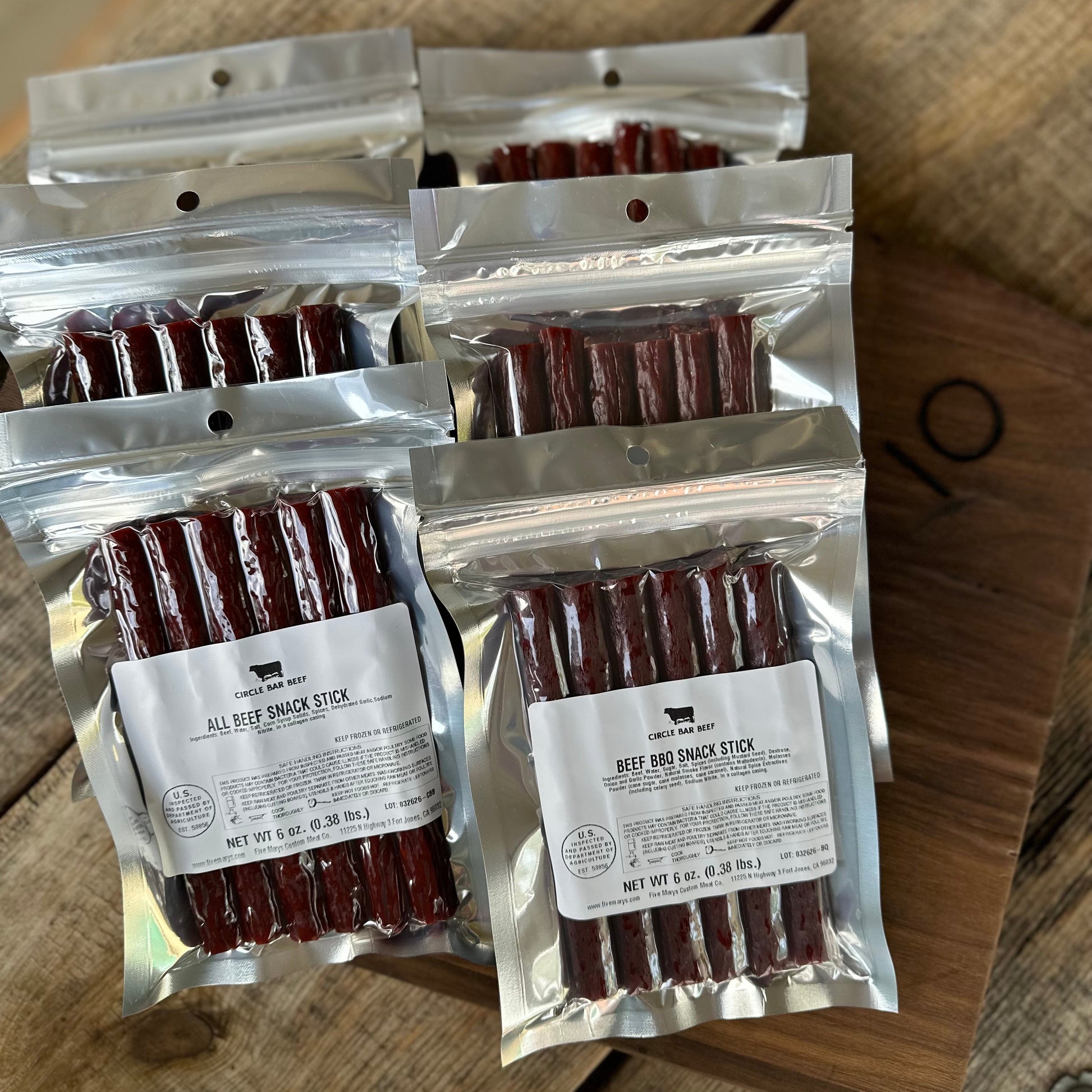 Packages of beef snack sticks on a wooden surface