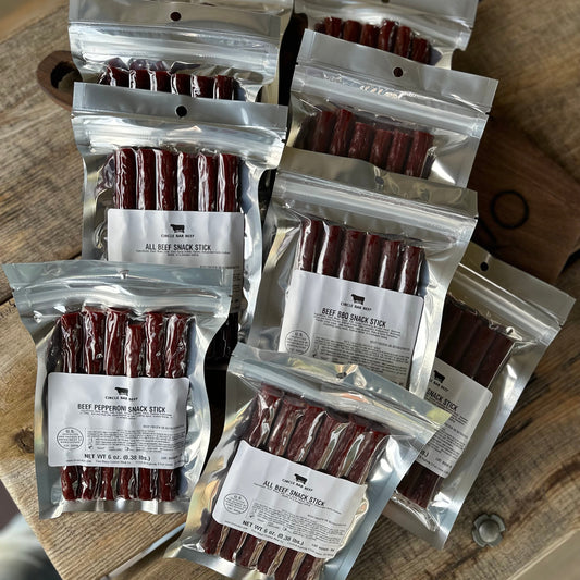 Multiple packages of beef snack sticks on a wooden surface